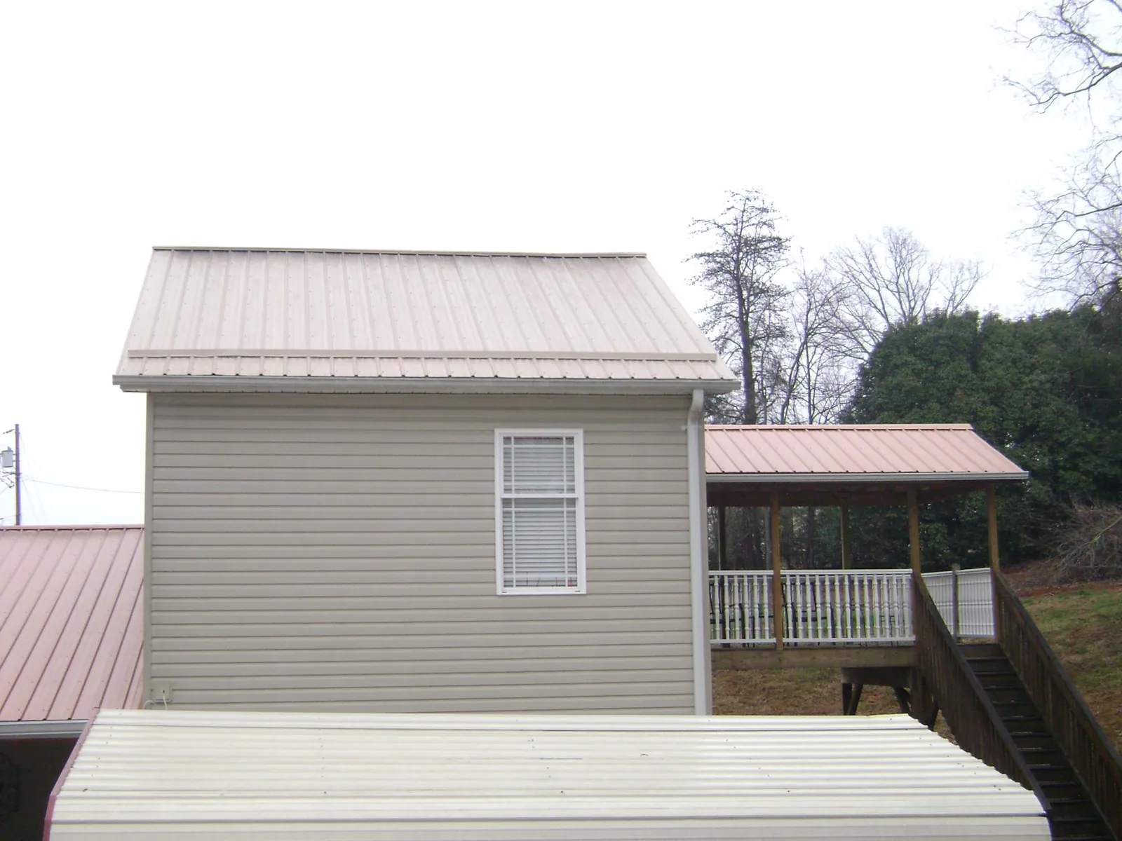 Tan metal roofs on a two story addition and attached porch, from a Roof Replacement job in Edmonds